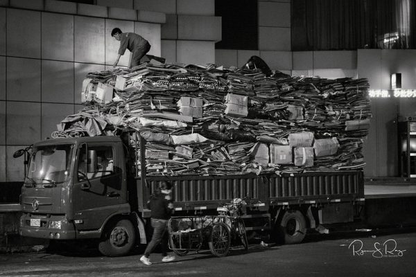 Men load an already heavily laden truck
