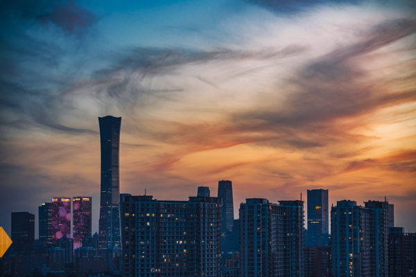 Dark wisps of cloud above the Beijing skyline at sunset
