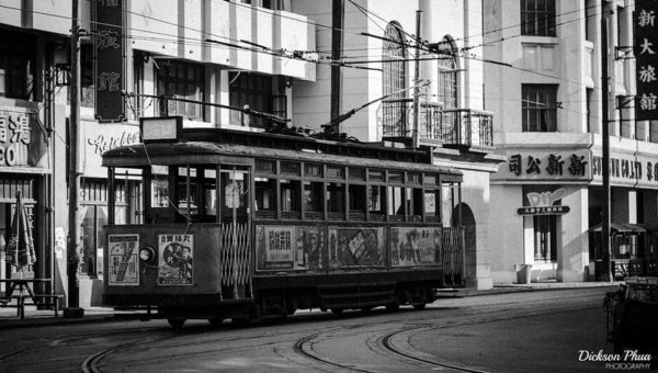 Taken on a set at Shanghai Film Park, this grainy, black and white image shows a trolley car passing through an old Shanghai commercial neighborhood of days gone by.