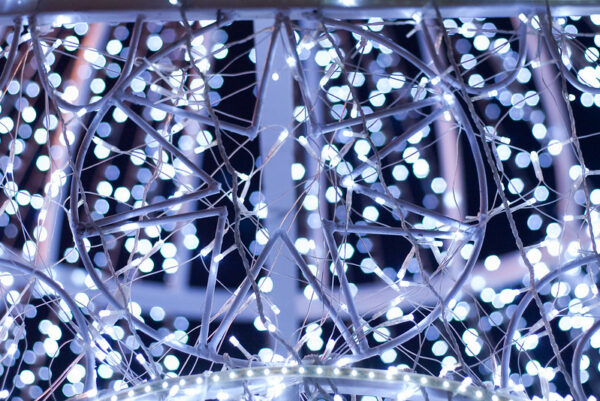 A festive display of holiday lights in Tianjin features star shapes and blue, purple, and white hues.